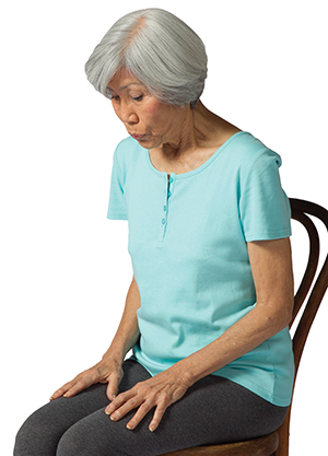Woman doing tension release exercise, exhaling through mouth.